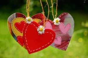 three red hearts hanging with white flowers